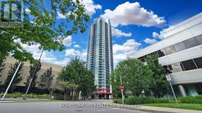 Toronto (Willowdale East) condo for rent - A tall building stands in front of a Home Comfort Realty Inc. sign.