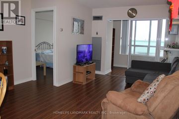 Toronto (Newtonbrook East) condo for rent - A living room with a brown couch and a flat screen TV.