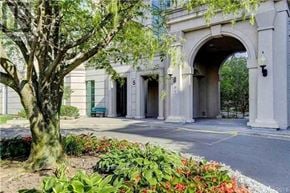 Vaughan (Crestwood-Springfarm-Yorkhill) condo for rent - A white building with a large arched entrance and a tree in front.