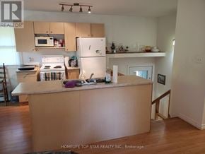 Marmora And Lake (Marmora Ward) apartment for rent - A kitchen with a white refrigerator and a wooden island.