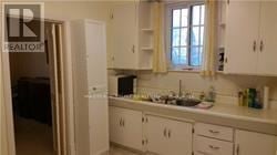 Toronto (Bedford Park-Nortown) apartment for rent - A kitchen with white cabinets and a window.