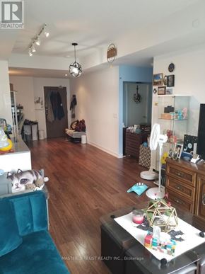 Toronto (Bayview Village) condo for rent - A living room with a blue couch and a wooden floor.