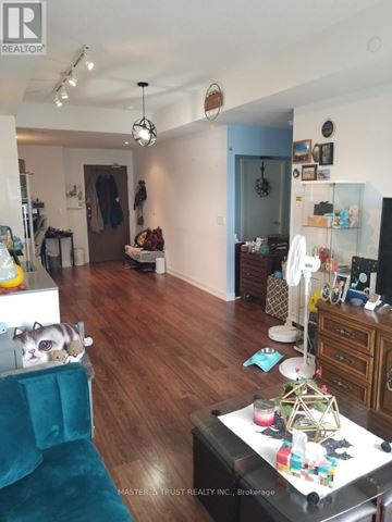 Toronto (Bayview Village) condo for rent - A living room with a blue couch and a wooden floor.