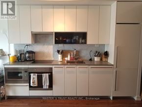 Toronto (Bayview Village) condo for rent - A kitchen with white cabinets and a wooden floor.