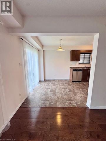 Kitchener apartment for rent - A room with a kitchen in the background and a tiled floor.