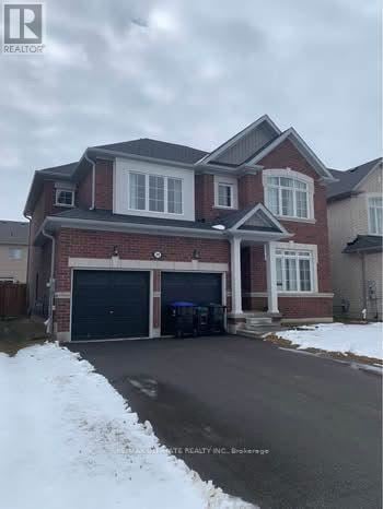 Collingwood apartment for rent - A large house with a garage is surrounded by snow.