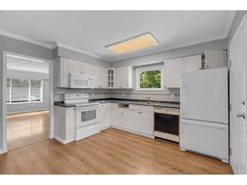 Delta apartment for rent - A kitchen with white appliances and cabinets.
