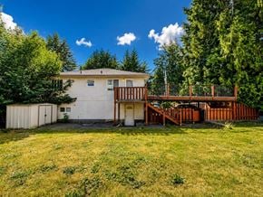 Delta apartment for rent - A house with a white exterior and a brown deck.