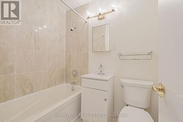 Toronto (The Beaches) multi-family for rent - A white bathroom with a tub, toilet, and sink.