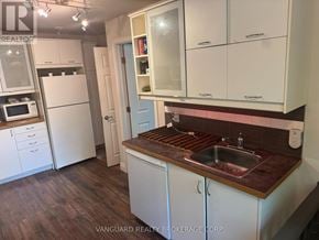 New Tecumseth (Alliston) triplex for rent - A kitchen with white cabinets and a brown countertop.