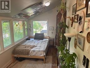 New Tecumseth (Alliston) triplex for rent - A bedroom with a bed, a window, and a lamp.