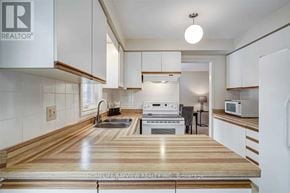 Newmarket (Bristol-London) apartment for rent - A modern kitchen with white cabinets and a wooden countertop.