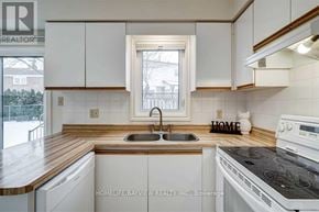 Newmarket (Bristol-London) apartment for rent - A kitchen with white cabinets and a wooden countertop.