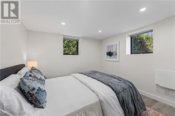 Sudbury apartment for rent - A bedroom with a bed, pillow, blanket, and two windows.