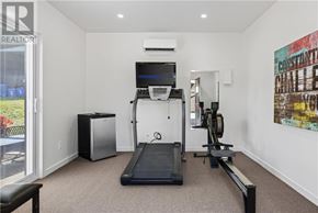 Sudbury apartment for rent - A room with a treadmill, a television, and a weight machine.