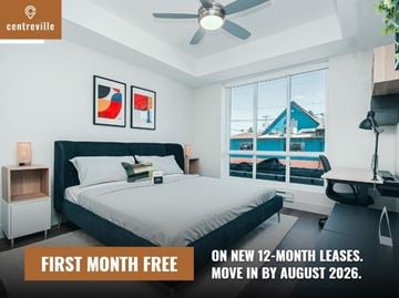 Chilliwack apartment for rent - A bedroom with a bed, a desk, and a window overlooking a blue house.