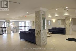 Markham (Unionville) condo for rent - A spacious lobby with a marble pillar and a blue couch.