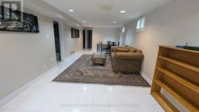 Mississauga (Erin Mills) apartment for rent - A living room with a rug, a couch, and a TV mounted on the wall.