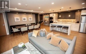 Oakville (Oa Rural Oakville) condo for rent - A modern living room with a grey sofa and a coffee table.