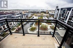 Oakville (Oa Rural Oakville) condo for rent - A balcony view of a residential area with apartment buildings and a roundabout.