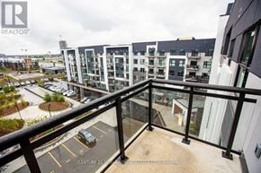 Oakville (Oa Rural Oakville) condo for rent - A balcony overlooks a parking lot and buildings.