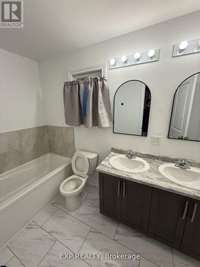 Welland (N. Welland) apartment for rent - A bathroom with a toilet, sink, and mirror.