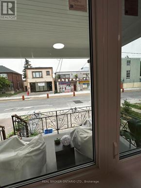 Toronto (Oakwood Village) duplex for rent - A view from inside a building looking out to a street with a Real Broker sign.