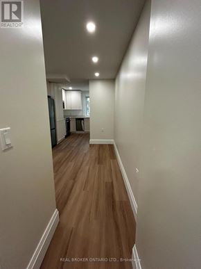 Toronto (Oakwood Village) duplex for rent - A hallway with wood flooring and white walls.
