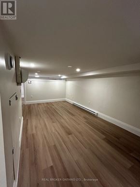 Toronto (Oakwood Village) duplex for rent - A room with wooden flooring and white walls.