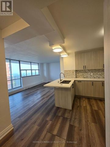 Toronto (Mount Olive-Silverstone-Jamestown) condo for rent - A well-lit kitchen with wooden floors and white cabinetry.