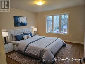 Bayham (Vienna) apartment for rent - A bedroom with a large bed and a window overlooking a residential area.