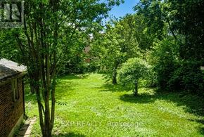 Mississauga (Streetsville) apartment for rent - A lush green garden with trees and a house in the background.