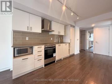 Toronto (Mount Pleasant West) condo for rent - A kitchen with white cabinets and a microwave above the oven.
