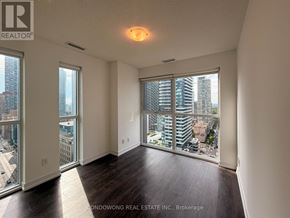 Toronto (Mount Pleasant West) condo for rent - A large, empty room with a view of the cityscape outside the windows.