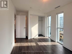Toronto (Mount Pleasant West) condo for rent - A spacious room with a door leading to another room and a window overlooking a cityscape.