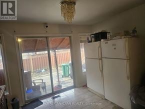 Brampton (Fletcher's Creek South) apartment for rent - A kitchen with a white fridge and a chandelier hanging from the ceiling.