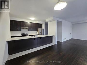 Hamilton (Stoney Creek) townhouse for rent - A kitchen with dark wood cabinets and a white countertop.