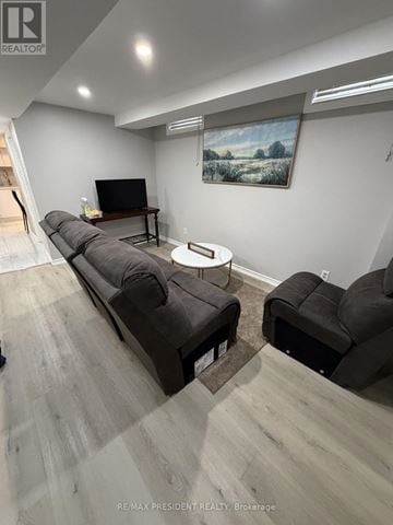 Mississauga (Malton) apartment for rent - A living room with a grey sofa and a painting on the wall.
