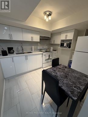 Mississauga (Malton) apartment for rent - A kitchen with white cabinets and a granite countertop.