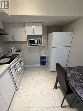 Mississauga (Malton) apartment for rent - A kitchen with white appliances and a granite counter.