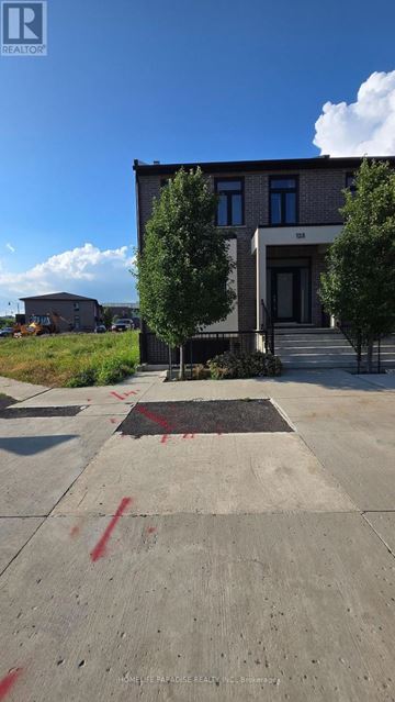 Pelham (Fonthill) house for rent - A building with a black door and windows is surrounded by trees and a concrete area with red markings.