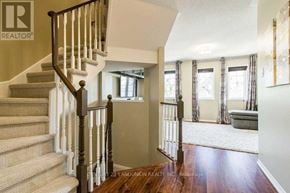 Oakville (Ro River Oaks) apartment for rent - A staircase with a wooden handrail and beige carpeted steps leads to a living room.