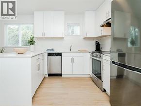 Vancouver apartment for rent - A white kitchen with wooden floors and stainless steel appliances.