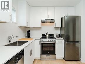 Vancouver apartment for rent - A kitchen with white cabinets and a stainless steel refrigerator.