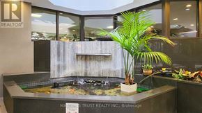Toronto (Kensington-Chinatown) condo for rent - A small waterfall in a fish tank with a sign that says "MARSH TRUST REALTY INC., Brokerage".