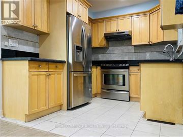 Toronto (Dorset Park) apartment for rent - A kitchen with wooden cabinets and a stainless steel refrigerator.