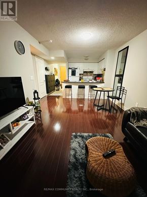 Toronto (Bendale) condo for rent - A living room with a television, a couch, and a guitar on the floor.