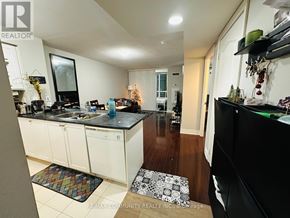 Toronto (Bendale) condo for rent - A kitchen with white cabinets and black countertops.