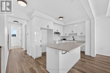 Oakville (Jm Joshua Meadows) townhouse for rent - A spacious kitchen with white cabinets and a central island.