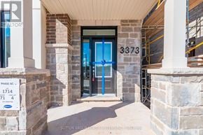 Oakville (Jm Joshua Meadows) townhouse for rent - The entrance to a building with a sign that reads "REALTOR" and a blue door.
